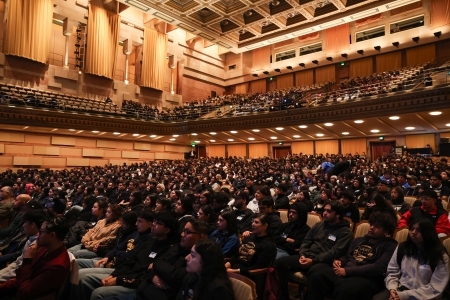 conference attendees fill the interior of an auditorium.