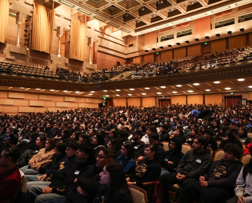 conference attendees fill the interior of an auditorium.