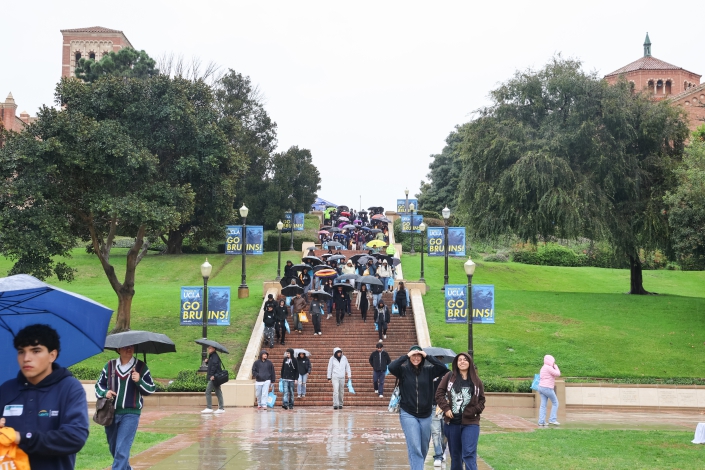 People walk through the Tongva Steps at UCLA in the rain.