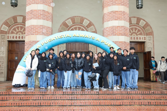 a group of students pose in front of an arch
