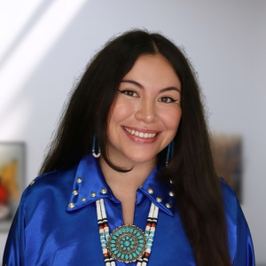 A woman with long dark hair and a blue collared shirt 